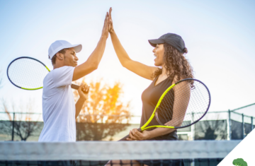 Ein Mann und eine Frau geben sich auf einem Tennisplatz ein High-Five, während sie Tennisschläger in der Hand halten. Beide tragen sportliche Kleidung und Kappen, und die Szene wird von warmem Sonnenlicht im Hintergrund erhellt. Das High-Five symbolisiert die Energie, Vitalität und den Teamgeist, die durch eine bewusste Lebensweise und Ernährung – wie der veganen Ernährung – gefördert werden können. Es unterstreicht die Aussage des Titels **"Sportliche Vorteile durch vegane Ernährung – Wissenschaftliche Einblicke und Erfahrungsberichte"**, indem es aufzeigt, wie eine ausgewogene pflanzliche Ernährung positive Auswirkungen auf Leistungsfähigkeit und Wohlbefinden im Sport haben kann. In der unteren rechten Ecke befindet sich das Logo von **"Vegane Sporternährung für alle" by Anne Mayer**, dargestellt durch ein grünes Brokkoli-Icon.