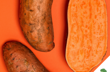 Drei Süßkartoffeln auf orangefarbenem Hintergrund, eine davon aufgeschnitten und mit gut sichtbarem, leuchtend orangem Inneren.