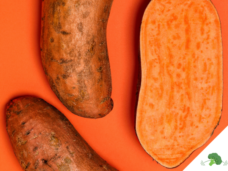 Drei Süßkartoffeln auf orangefarbenem Hintergrund, eine davon aufgeschnitten und mit gut sichtbarem, leuchtend orangem Inneren.