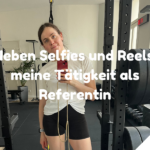Frau steht in Sportkleidung in einem Fitnessraum, hält ein Smartphone in der Hand und macht ein Spiegelselfie. Im Hintergrund sind Hanteln, Geräte und Pflanzen zu sehen. Auf dem Bild ist ein Text eingeblendet: „Neben Selfies und Reels: meine Tätigkeit als Referentin“.