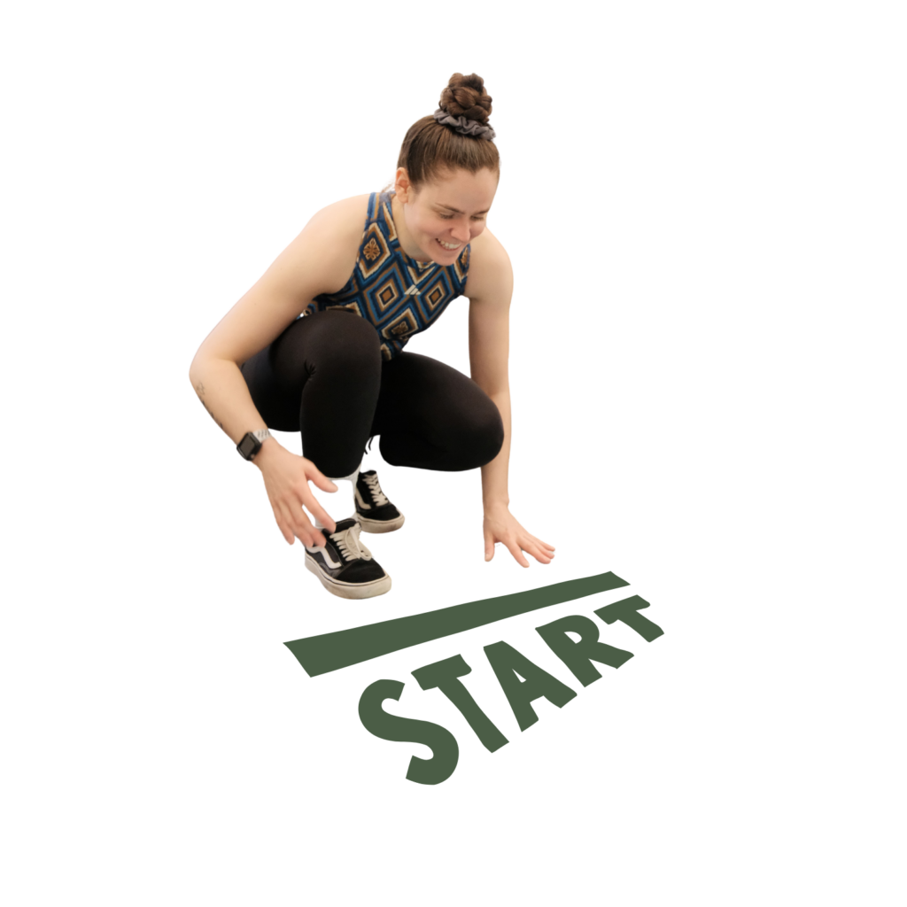 Junge Frau in Sportkleidung hockt lächelnd an einer Startlinie mit der Aufschrift „START“ und bereitet sich auf den Start vor.