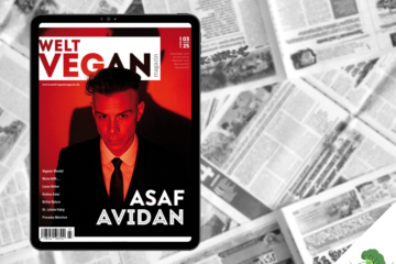 Tablet mit dem Cover der Ausgabe 03|2025 des Welt Vegan Magazins, auf dem der Künstler Asaf Avidan in rotem Licht abgebildet ist, im Hintergrund eine schwarz-weiße Collage aus geöffneten Zeitungsseiten, unten rechts das Logo „Vegane Sporternährung für alle“.