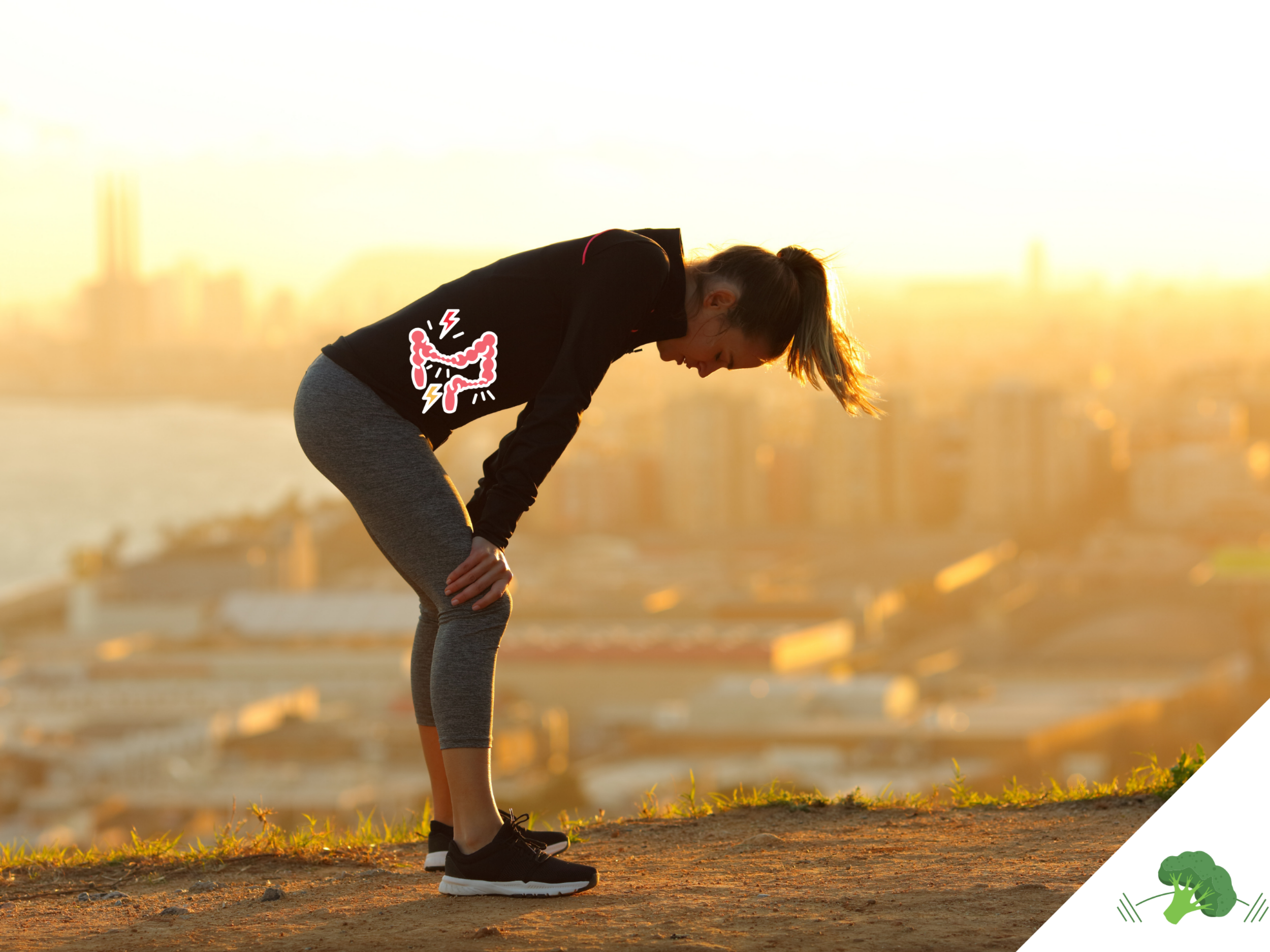 Sportlerin steht beim Laufen auf einem Hügel im Sonnenuntergang, nach vorne gebeugt mit den Händen auf den Knien abgestützt, während eine grafische Darstellung eines schmerzenden Darms im Bauchbereich eingeblendet ist; im Hintergrund ist eine Stadt unscharf zu sehen