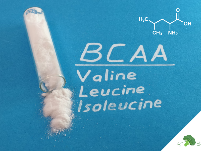 Reagenzglas mit weißem Pulver auf blauem Hintergrund, daneben die Aufschrift BCAA mit den Begriffen Valine, Leucine und Isoleucine sowie die chemische Strukturformel von Leucin oben rechts