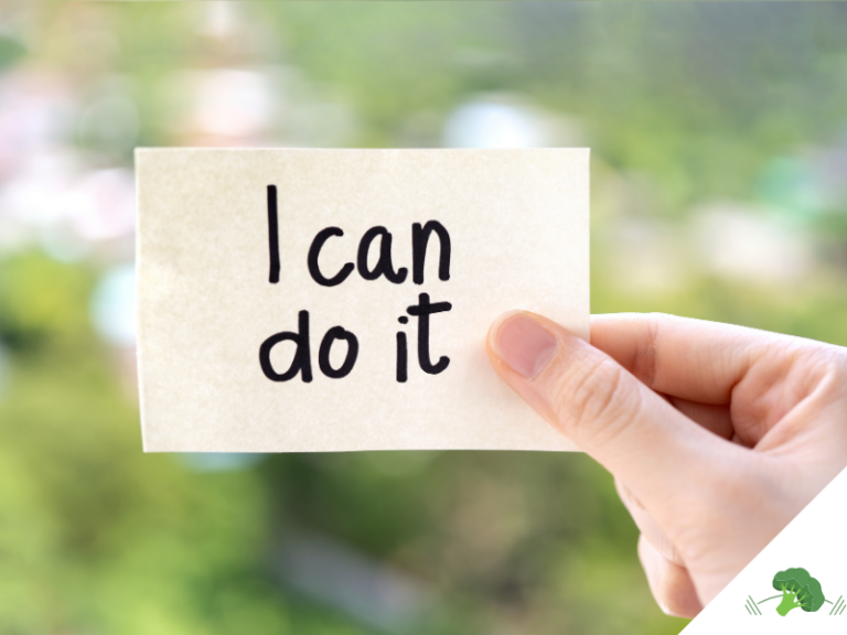 Hand hält einen Zettel mit der handgeschriebenen Aufschrift I can do it vor unscharfem grünem Hintergrund als Symbol für Motivation bei veganer Ernährung